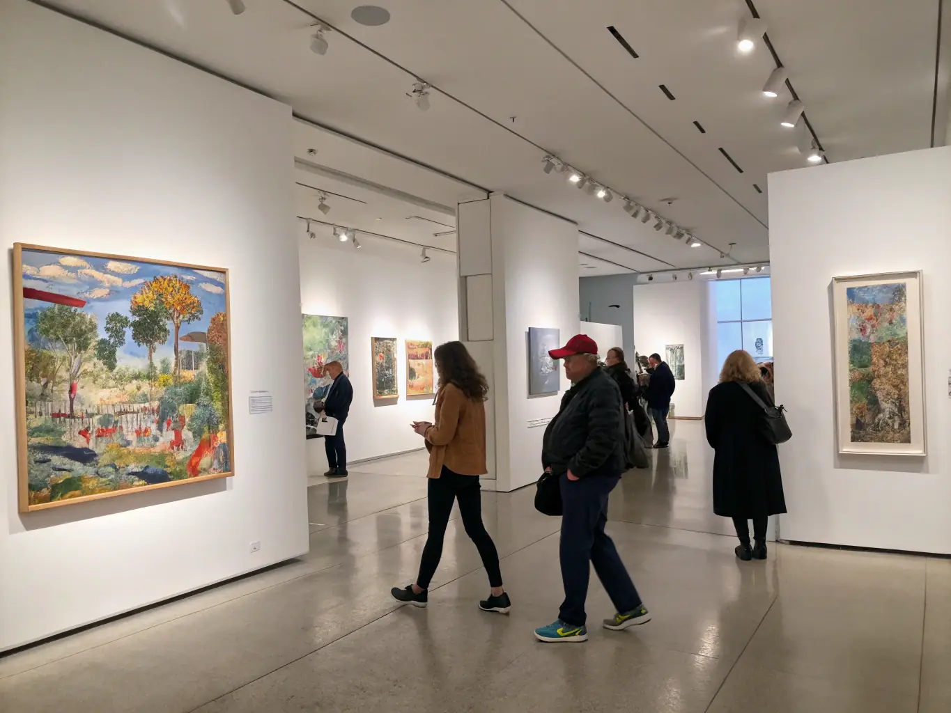 An image showcasing a visual arts exhibition, featuring diverse artworks and visitors engaging with the art, highlighting the organization's support for visual artists.